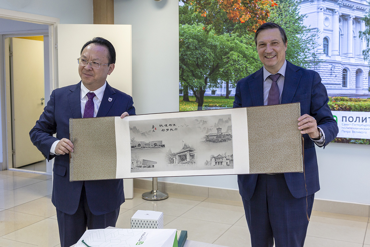 Prof. Tan Tieniu and Vice-Rector Dmitry Arseniev exchanging gifts