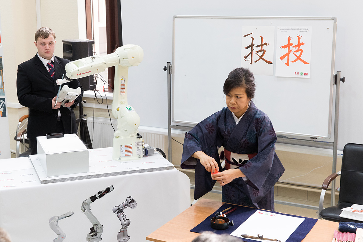 The honorable guests watched the matchup between the robot and the calligrapher 